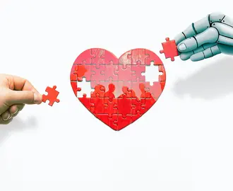 A robot hand and a human hand work on a heart puzzle with the silhouette of people inside