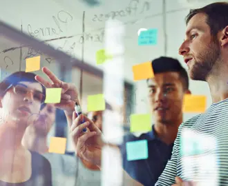 A team working on a glass board with sticky notes