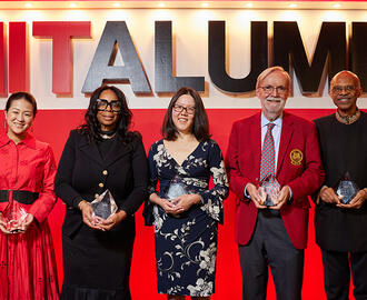 Group of people stands on stage holding awards