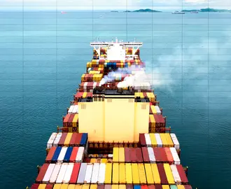 A cargo ship sails in the sea with emissions. A spreadsheet is overlayed on top.