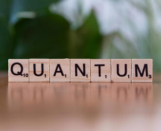 Scrabble pieces spell out the word "Quantum"