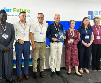 Event panelists, moderator, and organizers stand together.