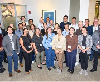 Group of 27 people stand and pose for a picture. 