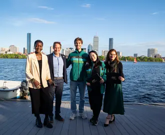 members of the SISC group in front of the river and boston skyline