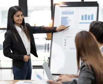 Confident business woman standing in front of her company, presenting her project and ideas on a board.