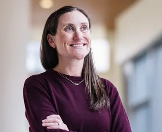 Laura in a maroon sweater crossing her arms