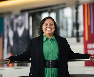 Solangel Fernandez in a green dress and black sweater