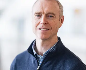 David Miller in front of blurry white background