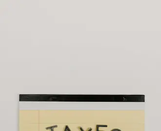 Yellow Notepad with the Word Taxes