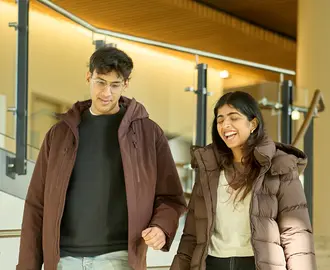 Two people talking while walking down stairs