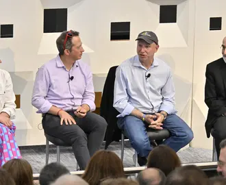 Panel of four people discuss topics onstage