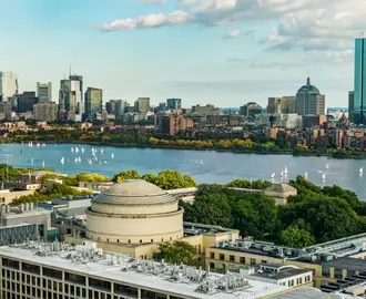 Aerial view of Boston across the Charles River with the MIT Great Dome in the foreground.
