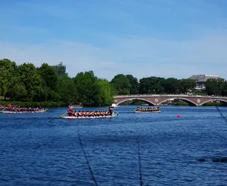 Several boats race down the Charles River in Cambridge