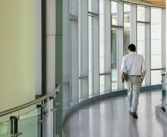 Man walking on the indoor bridge connecting building E62 with E52.