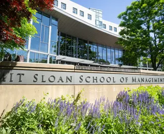 Exterior photo of MIT Sloan's main building E62 with plants