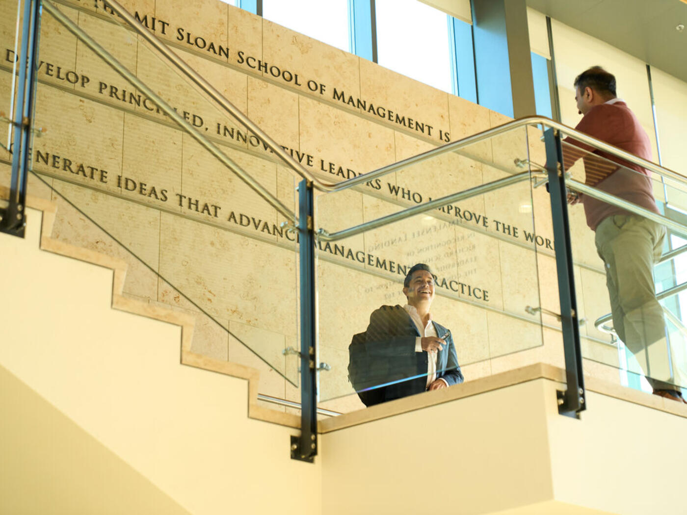 Students on staircase in E62 with MIT Sloan mission written on the wall in the background: THE MISSION The mission of the MIT Sloan School of Management is to develop principled, innovative leaders who improve the world and to generate ideas that advance management practice.