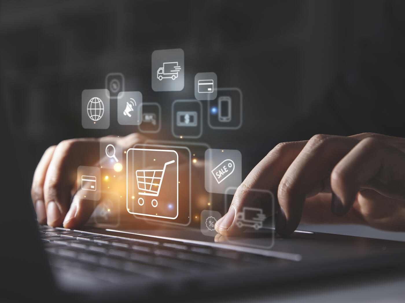 Young man using laptop with shopping cart icon