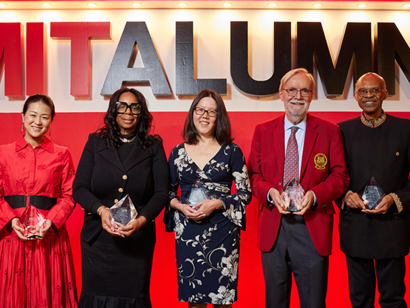 Group of people stands on stage holding awards