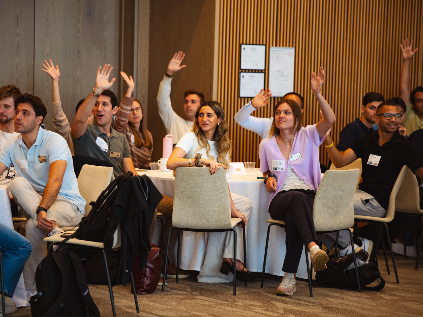 MIT MBA students raising their hands at an orientation program