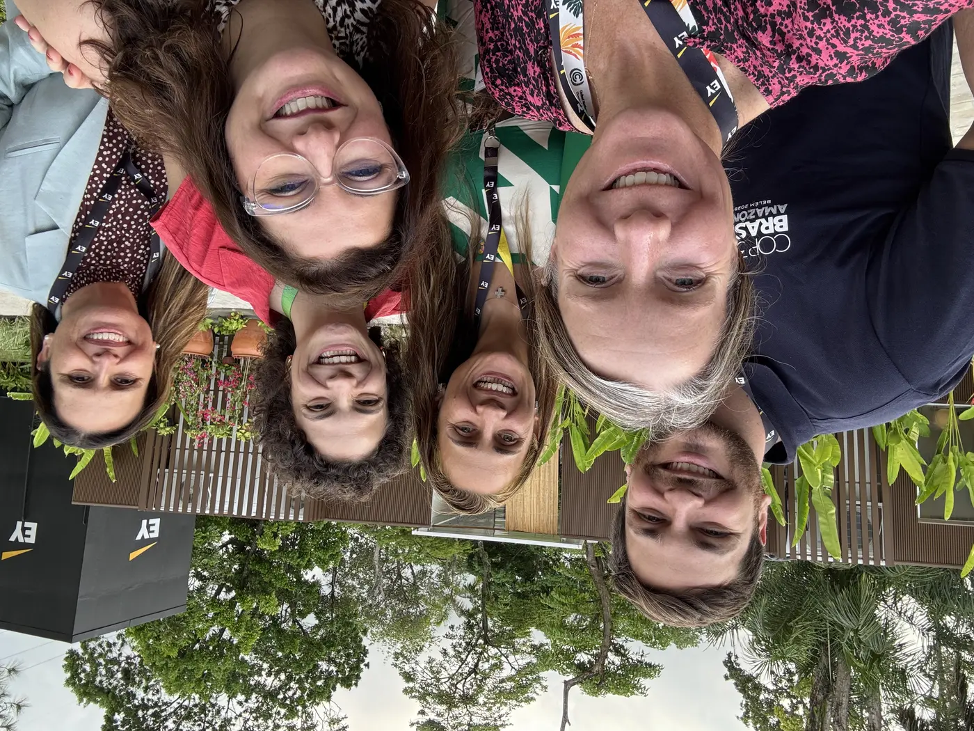 Group selfie of 6 smiling people outside.