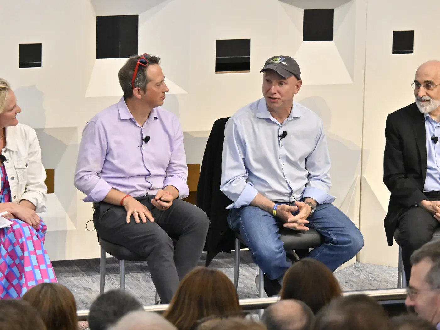 Panel of four people discuss topics onstage