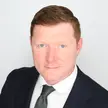 Man in suit poses for photo