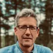 Man in glasses with short silver hair