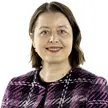 photo of a woman with medium-length brown hair and light eyes wearing a purple plaid jacket against a white background