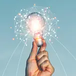 A person holds up a lightbulb covered in AI data imagery