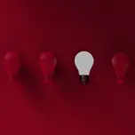 A row of red lightbulbs with 1 white one