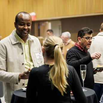 Two event attendees converse at a table