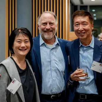 Three members of the MIT Sloan Alumni Board pose for a photo at an event.