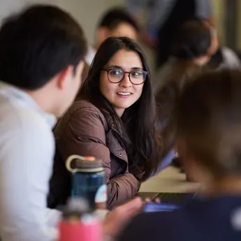 A student speaks with another student in an MIT Sloan classroom