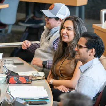 Three students working in MIT Sloan classroom