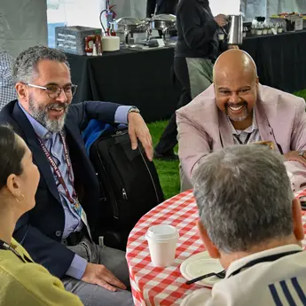 A group of smiling people converse at a social event.