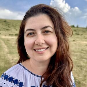 Headshot of a woman outdoors smiling into the camera.