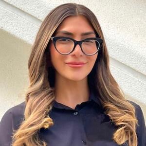 Photo of woman wearing glasses and dark-colored shirt