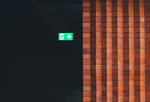 image of a brick wall with a glowing green exit sign