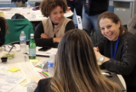 Women around a table at the MIT Sloan Hack for Inclusion
