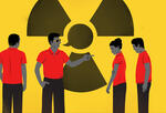 four workers in red shirts and dark pants with a radioactive danger symbol behind them