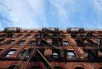 Street view looking up of brown brick building in urban setting