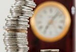 stacked coins with clock in background