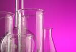 Glass laboratory beakers on fuchsia background.