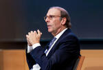 jim foster, seated, gestures to a crowd