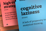 A illustration of three working definitions posts from Instagram. The text on two are obscured. The other reads 'Cognitive laziness (noun) - A lack of propensity to engage in analytical thinking.