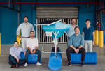 MIT Sloan students and bioFeeder co-founders posed around one of their shrimp-feeding systems.
