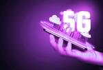 Hand holding smartphone with 3D city and word 5G coming out of screen.