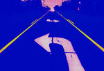 a road disappears into the horizon, with a large white turning arrow in the foreground