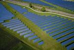 Solar panels appear in a field emphasizing the environmental aftermath of COVID-19.