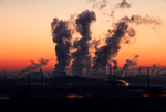 Pictured are smokestacks and factories against the backdrop of a city: what will the last effects of COVID-19 be on the environment?